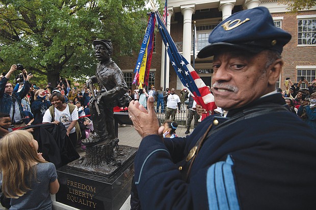 U.S. Colored Troops re-enactor Norman Hill applauds the new statue honoring Black enslaved men who enlisted and served in the Civil War. The statue, by Ohio sculptor Joe Frank Howard, was unveiled Oct. 23 outside the courthouse in Franklin, Tenn.