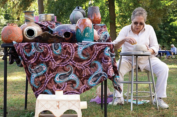 Kathy Reid, a retired Richmond Public Schools art teacher, uses her hands to create a new piece of pottery from clay.