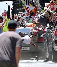 In this Aug. 12, 2017 photo, people fly into the air as a vehicle drives into a group of counterprotesters demonstrating against a rally by white nationalists angered by the City of Charlottesville’s plans to remove a statue of Confederate Gen. Robert E. Lee.