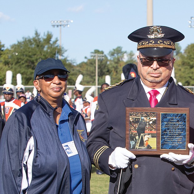 VSU President Makola Abdullah presents a plaque to the Rev. Sylvester Bullock, VSU’s assistant band director, who is retiring after 35 years of service to the Trojan Explosion March Band.