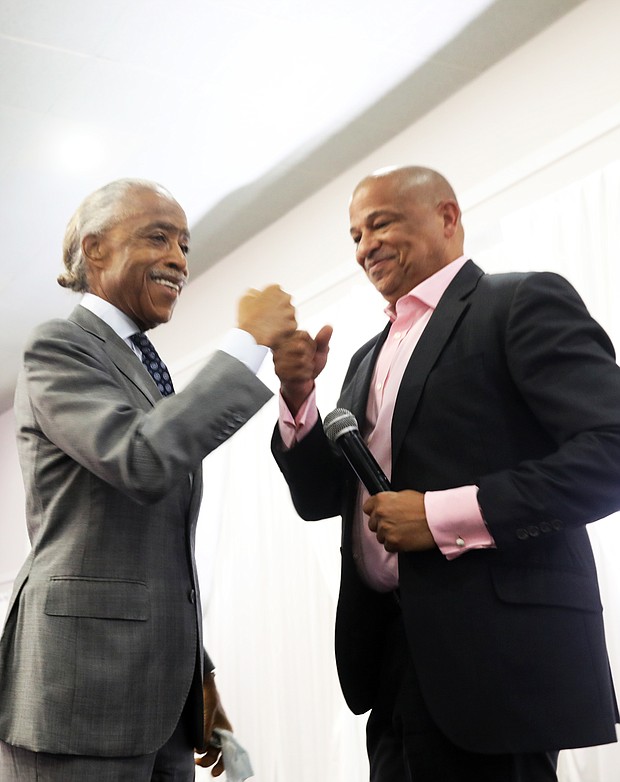 Rev. Al Sharpton, left, founder of the National Action Network, gives a fist bump to Alfred C. Liggins III, president and CEO of Urban One, at an event Saturday at the Royal Manchester Event Center with supporters of the proposed ONE Casino + Resort.