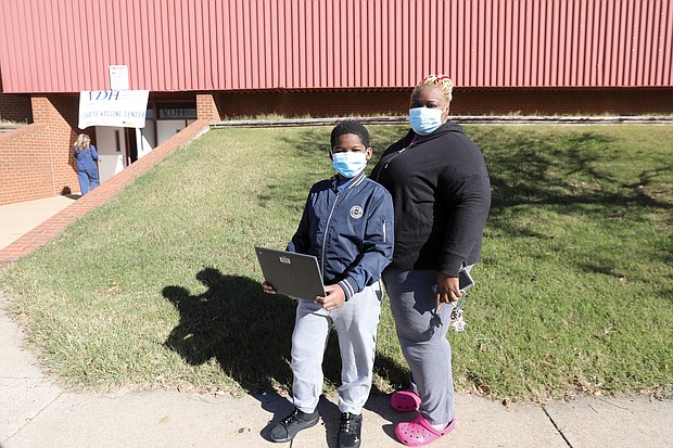 Jayden Holmes, 9, a student at Carver elementary School, is ready to get his COVID-19 vaccine. On Monday, he and his mother, Shankita Holmes, who works in nursing, were outside the Arthur Ashe Jr. Athletic Center on Arthur Ashe boulevard, which has been set up as a community vaccination center by local health officials. The youngster, who was nervous about getting a needle, survived the shot and said he was feeling good when he left. Children ages 5 to 11 are now eligible to receive the vaccine.
