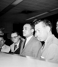 Khalil Islam, second from right, is booked on March 3, 1965, in the slaying of Malcolm X in New York on Feb. 21, 1965. Mr. Islam, who is being held by Detective John Keeley, right, died in 2009 after serving more than a decade in prison. He was paroled in the 1980s.