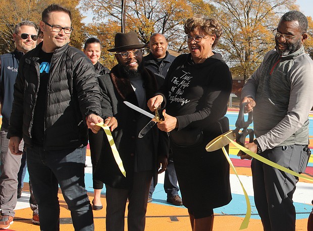 City Councilwoman Ellen F. Robertson, 6th District, second from right, cuts the ribbon to formally open the new basketball courts in the Hillside Court public housing community in South Side. Joining in the ceremony last Saturday are, from left, Nicholas J. “Nick” Cooper of Citizen HKS, the nonprofit that led the design effort with residents; Tavares Floyd, Ms. Robertson’s council liaison; and Ralph Stuckey, director of resident services for the Richmond Redevelopment and Housing Authority.