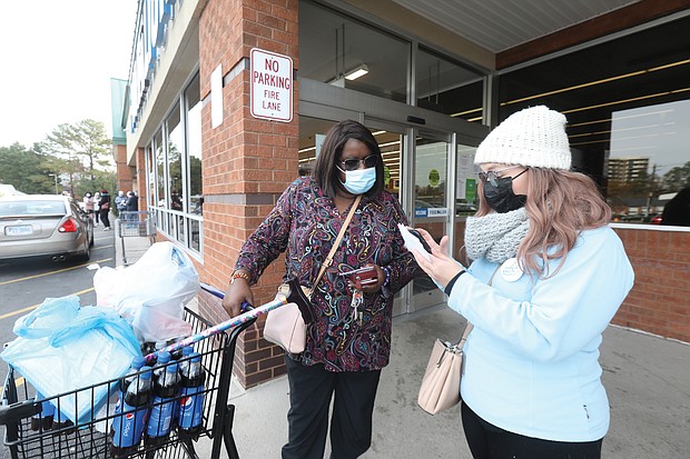 Debra Timmons, left, listens to information provided by Rachel Hefner of the nonprofit Virginia Organizing advocacy group about the campaign to secure paid sick leave for grocery store workers last Saturday outside the Food Lion in the 6800 block of Forest Hill Avenue. Ms. Hefner was among the group of activists who took part in a statewide campaign to educate shoppers about working conditions for supermarket employees. According to campaign information, only a few companies provide paid sick leave, leaving two-thirds of such workers uncovered.