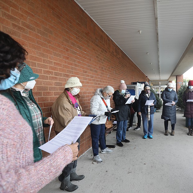 Rev. Patricia Shipley, fourth from left, a board member of the Richmond-based Virginia Interfaith Center for Public Policy leads campaign supporters in a prayerful litany outside South Richmond Food Lion. Joining her are members of the Greater Richmond Branch of the American Association of University Women, Virginia Organizing and Green New Deal who were there to advocate on behalf of workers.