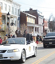 Richmond Mayor Levar M. Stoney and his girlfriend, Brandy Washington, wave to the crowd from their perches on the back of a classic Mustang during last Saturday’s parade.