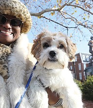 Monica Davis Williams of Chesterfield carries her 8-month-old Shih Tzu-Yorkie mix, Seymoure, as she watches for her mother, Mary Carr Davis, a member of the Maggie Walker Class of 1967 and former co- captain of the cheerleading squad, who was participating in the parade.