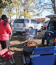 Tailgaters enjoy a fire pit during the tailgate party on the VUU campus following the parade.