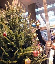 The holiday season has arrived in Richmond with the official launch party Tuesday at City Hall in Downtown. Mayor Levar M. Stoney helps decorate the city’s first Unity Tree that celebrates Christmas, Hanukkah and Kwanzaa during the kick-off event in the first-floor lobby.
Tuesday’s festive event also featured the Richmond Police Department’s 11-member brass band performing holiday music. The holiday celebration will continue in the coming days, featuring RVA Illuminates on Friday, Dec. 3, at Kanawha Plaza in Downtown to turn on building lights and the Christmas Parade on Saturday, Dec. 4.