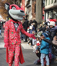 Characters interacted with youngsters along the parade route. Nutzy, the mascot of the Richmond Flying Squirrels, shows off his holiday attire.