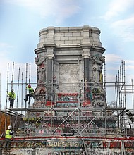 Workers secure scaffolding around the 40-foot tall granite pedestal on Monument Avenue that once held the towering statue of Confederate Gen. Robert E. Lee. The work to remove the pedestal began Monday.