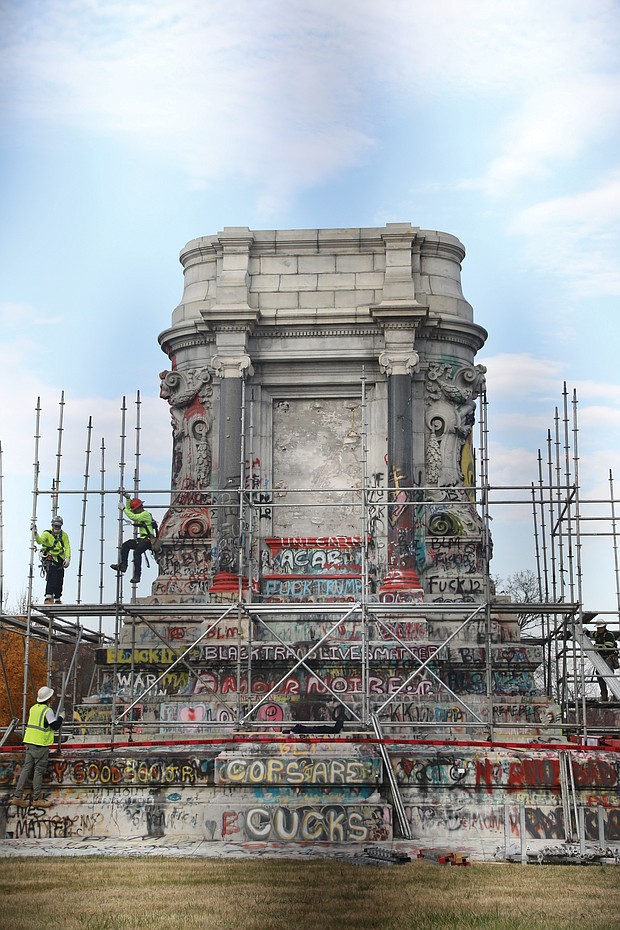Workers secure scaffolding around the 40-foot tall granite pedestal on Monument Avenue that once held the towering statue of Confederate Gen. Robert E. Lee. The work to remove the pedestal began Monday.