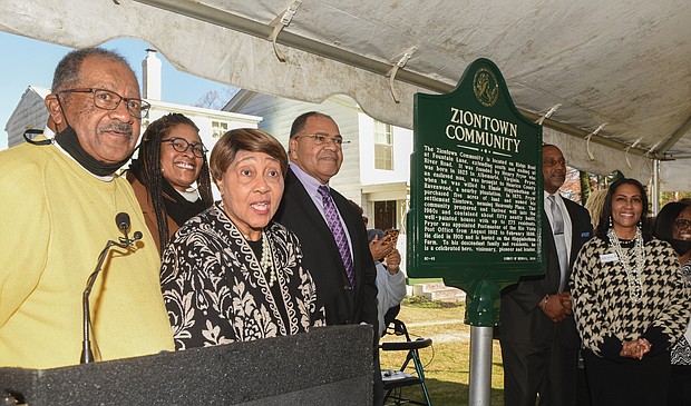 A new historic marker recognizing the Ziontown community in Henrico County was dedicated Dec. 3 in a ceremony hosted by the Family & Friends of Ziontown and the Henrico Historic Preservation Advisory Committee as part of the Historical Roadside Marker program.The community was founded in 1870 by Henry Pryor, a formerly enslaved man, who purchased 5 acres around the area now known as Ridge Road at Fountain Lane and extending south to River Road. He named the settlement Ziontown, meaning Heavenly Place. The community grew to include about 50 homes with up to 275 residents. Subdivisions have encroached upon the area in recent decades. Last week’s celebration drew longtime residents, as well as those who grew up in the area and others with ties to the community, including the Lambert family, whose home in the 8300 block of Ridge Road served as the site of the dedication. Among the attendees are, from left, John A. Lambert Sr.; Richmond City Councilwoman Ann-Frances Lambert; Brenda Dabney Nichols, who led the marker effort; Richard A. Lambert; the Rev. Larry Collins; and Dr. Colita Nichols Fairfax.