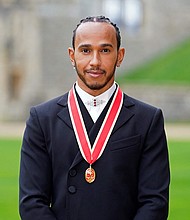 Mercedes' British F1 driver Lewis Hamilton poses with his medal after being appointed as a Knight Bachelor for services to motorsports, at Windsor Castle in Windsor, west of London on December 15
Mandatory Credit:	Andrew Matthews/AFP/Getty Images