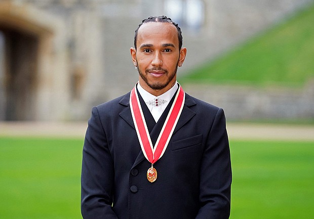 Mercedes' British F1 driver Lewis Hamilton poses with his medal after being appointed as a Knight Bachelor for services to motorsports, at Windsor Castle in Windsor, west of London on December 15
Mandatory Credit:	Andrew Matthews/AFP/Getty Images