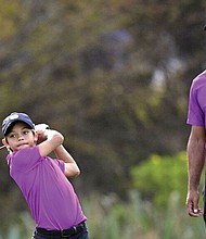 Tiger Woods playing gold with his son, Charlie.