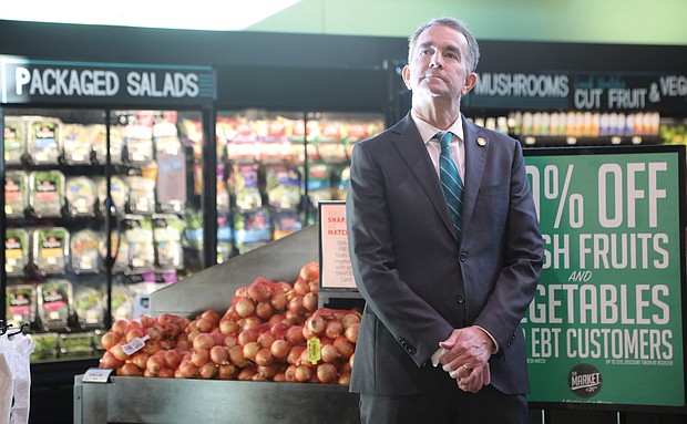 Gov. Ralph S. Northam pauses Tuesday in the produce section at The Market @ 25th in the East End before stepping up to a podium to announce several tax cuts in his proposed 2022-24 budget, including elimination of the state tax on groceries. He was joined at the news conference by State Finance Secretary Joe Flores and state Sens. Joe Morrissey and Ghazala Hashmi.