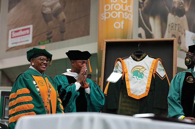 Award-winning musician and Virginia Beach native Pharrell Williams is overcome with emotion last Saturday as he is made an honorary member of the Norfolk State University Spartan Legion Marching Band and presented with a framed band uniform by NSU President Javaune Adams-Gaston. He also was awarded an honorary doctorate by the university.