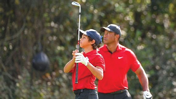 Tiger Woods watches where the ball lands after his son, Charlie, swings during the PNC Father-Son Challenge last weekend in Orlando, Fla.