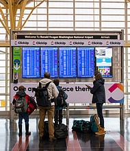 A family looks at flight information at Reagan National Airport in Arlington, Virginia, on Friday, Dec. 24.
Eric Lee/Bloomberg/Getty Images