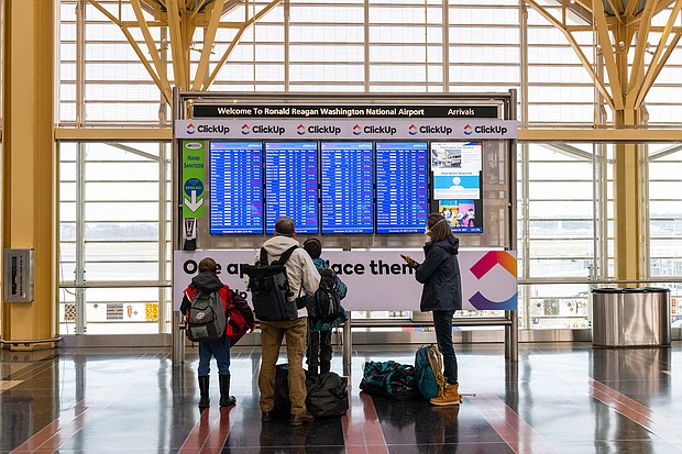 A family looks at flight information at Reagan National Airport in Arlington, Virginia, on Friday, Dec. 24.
Eric Lee/Bloomberg/Getty Images