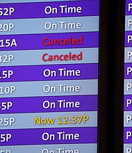 Canceled flights are noted in red on an electronic arrival board in the terminal of Denver International Airport, Friday, December 24, in Denver.
Mandatory Credit:	David Zalubowski/AP