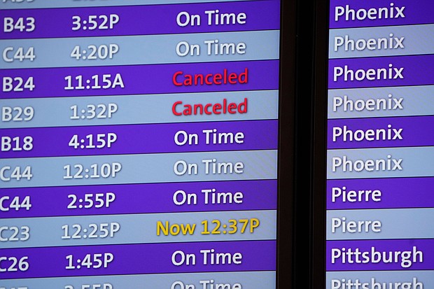 Canceled flights are noted in red on an electronic arrival board in the terminal of Denver International Airport, Friday, December 24, in Denver.
Mandatory Credit:	David Zalubowski/AP