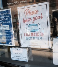 A sign on the door of a coffee shop in Manhattan asks for proof of vaccination and the wearing of a mask on the day that a mask mandate went into effect in New York on December 13.
Mandatory Credit:	Spencer Platt/Getty Images