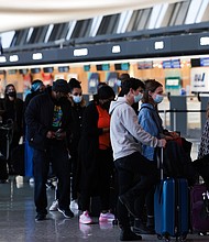 Passengers wait in line to check-in for their flights at the Dulles International Airport in Dulles, Virginia, on December 27.
	Anna Moneymaker/Getty Images