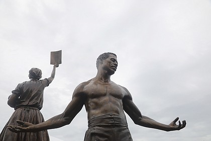 Two 12-foot bronze statues comprising the Emancipation and Freedom Monument are unveiled and dedicated during a ceremony Sept. 22 before several hundred people at Brown’s Island in Downtown.