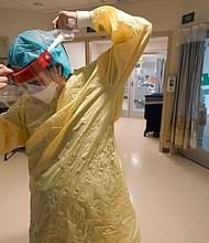 Registered nurse Sara Nystrom, of Townshend, Vt., prepares to enter a patient's room in the COVID-19 Intensive Care Unit at Dartmouth-Hitchcock Medical Center, in Lebanon, N.H., Monday, Jan. 3.
Mandatory Credit:	Steven Senne/AP