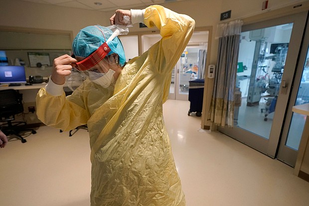 Registered nurse Sara Nystrom, of Townshend, Vt., prepares to enter a patient's room in the COVID-19 Intensive Care Unit at Dartmouth-Hitchcock Medical Center, in Lebanon, N.H., Monday, Jan. 3.
Mandatory Credit: Steven Senne/AP