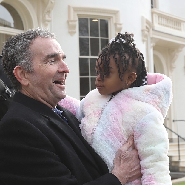 Gov. Ralph S. Northam greets 3-year-old Kamara Townes following the Jan. 7 renaming and dedication of a row of state-owned historic homes on Governor Street in Capitol Square. Both the governor and the youngster occupy a place in Virginia history. Gov. Northam is the 73rd governor of the Commonwealth, serving from Jan. 13, 2018, until his term ends this Saturday, Jan. 15. Last week, he dedicated the three newly renovated buildings, formerly known as Morson’s Row, in honor of Dr. William Ferguson “Fergie” Reid, the first Black person elected to the General Assembly following Reconstruction. One of the three buildings now called Reid’s Row was dedicated as the “Townes House,” in recognition of the Townes family that has worked at the Executive Mansion since the 1970s. Kamara is the youngest of that historic lineage. Her father, Martin C. Townes Jr., and his parents and sister are the current Townes family members serving there. Mr. Townes is the deputy butler, while his father, Martin “Tutti” Townes, is the head butler.