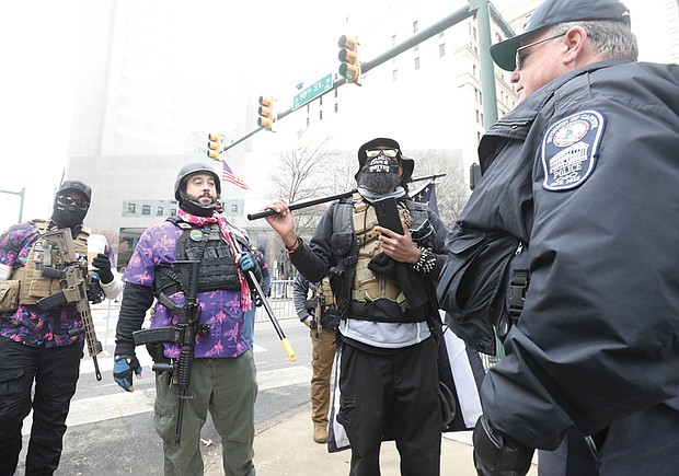 Black Lives Matter 757 organizer JaPharii Jones of Newport News, second from right, joins other gun rights advocates Monday for the annual General Assembly Lobby Day in Downtown. Police barricades and metal fencing were put up around Capitol Square, where no firearms were allowed. Because this group was carrying weapons, the Capitol Police officer asked them to move to the south side of 9th and Main streets, away from the state office buildings by the Capitol.