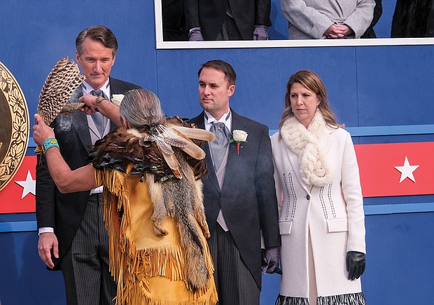 A representative of Virginia’s Indian Tribes performs a blessing over newly inaugurated Gov. Glenn A. Youngkin following his inaugural address. Members of several tribes took part in the Blessing of the Ground in front of the State Capitol, which has become a traditional part of the state’s inaugural ceremonies. At right are Attorney General Jason Miyares and his wife, Page Atkinson Miyares.