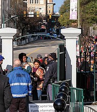 A long line of people wait at the gate at 9th and Grace streets to go through security to enter Capitol Square for the inauguration.