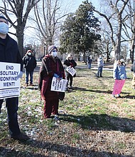 Prison justice advocates and members stand together but apart at the rally.