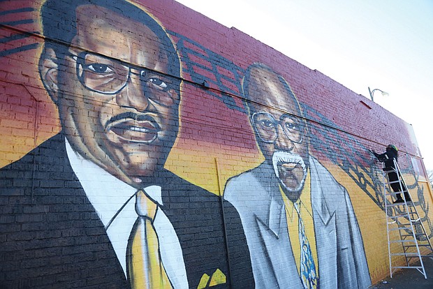 Sir James Thornhill puts the finishing touches on his latest mural, a salute to the founders of the storied Regular’s Social Club in North Side.
Marking its 64th year, the private men’s club commissioned the Richmond artist to create this tribute to founders, from left, the late Robert L. Harvey Sr. and Raymond Eldridge, on the north wall of the club’s home at 2521 Chamberlayne Ave. The two men, fed up with the exclusionary practices of other private Black clubs, joined with friends to start a group for ordinary workers like themselves, Mr. Harvey being an employee of A.H. Robins Co. and Mr. Eldridge being a letter carrier. 
“They called it the Regular’s Club because it was just for regular guys,” said Jesse J. Harrison III, a 50-year member who has served as the treasurer for several decades and is a former board chair.
Established in 1959, the club started with members going to each other’s houses, Mr. Harrison said. The club moved into the Chamberlayne Avenue building around 1971, he said, first renting and then purchasing it.
The club has hosted parties on weekends for members and guests, but has scaled back to monthly events since the pandemic, Mr. Harrison said. The club currently has about 40 members, he said, with room for more. Dues are $45 a month, he said.
Mr. Thornhill said he was delighted to be called on to create the mural. He noted that social clubs have a long history in Richmond’s Black community and that he was proud to help call attention to a place that has been around so long.
“This is part of telling the full story of the community,” he said.