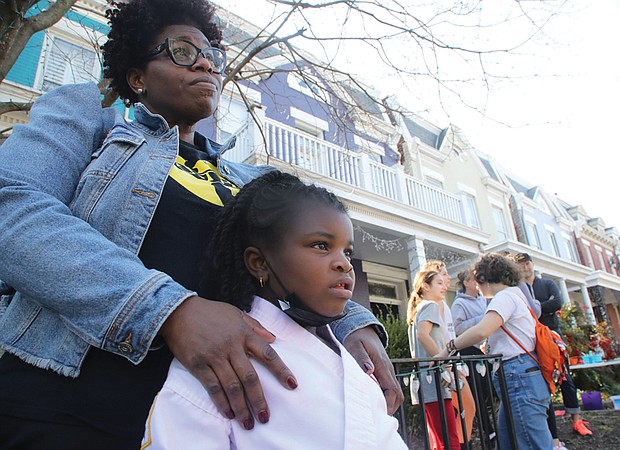 Tamara Ross and her daughter, Kori, 6, a kindergartener at Fox, view the damage to the school Saturday.