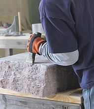 A stone cutter in Elberton, Georgia, uses a hammer and chisel to create the rough edges of a monument.
Mandatory Credit:	Courtesy Elberton Granite Association
