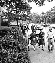 Carol Swann, right, and Gloria Mead are accompanied on their walk to Chandler Junior High School on their first day on Sept. 6, 1960, by Ms. Swann’s father, Frank Swann, and Ms. Mead’s mother, Florence Mead. News reporters and city police detectives also were at the school on the first day.