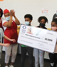 Joye B. Moore, founder and chief executive officer of Joyebells LLC, applauds as youngsters from the Northside Family YMCA display the $25,000 donation made by Sam’s Club on behalf of her company to support after-school programs at the YMCA of Greater Richmond. Ms. Moore was accompanied to the Feb. 17 check presentation by her sister, Cassandra Wheeler, left, Joyebells’ director of production. Accepting the donation is Abigail Farris Rogers, right, president and chief executive officer of the YMCA of Greater Richmond.