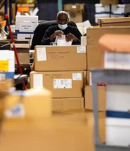 A Harris County Elections staff member at the Elections Technology Center warehouse in Houston on Tuesday. Credit: Annie Mulligan for The Texas Tribune