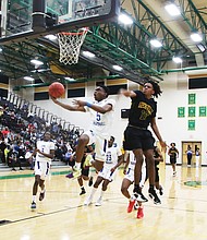 John Marshall High School’s Reggie Robertson, No. 5, leaps to make the basket during Monday night’s semifinal game against Greensville High School. Robertson, a senior, scored 14 points during the game played at Huguenot High School, helping the Justices to their 92-53 victory and advancement to the state championship game on Saturday, March 12, at the Siegel Center.