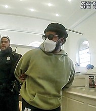 A police officer detains “Black Panther” director Ryan Coogler at a Bank of America branch in Atlanta in this Jan. 7 image taken from Atlanta Police video. Mr. Coogler was mistaken for a bank robber at the bank.