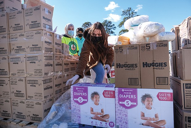 Ajnadeen Dahman, 17, is among a dozen youth volunteers helping to distribute diapers, baby formula and other giveaways during the Islamic Circle of North America Relief Richmond’s Drive-Thru Diaper Distribution last month at the ICNA Relief Resource Center in Henrico County. More than 150 cars drove through to pick up items that also included fresh fruits and vegetables and bread.