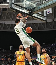 Forward Dana Tate Jr. of Norfolk State University goes sky high above Coppin State University players for a dunk during the MEAC title game last Saturday at the Norfolk Scope Arena. The Spartans are scheduled to face NCAA defending champion Baylor University on Thursday in Texas.