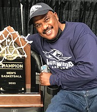 Randy Johnson, who played on the Longwood team in 1979-80 that went to the NCAA Division III Final Four, holds the Big South Tournament trophy won March 6 by Longwood, giving the team a berth in the NCAA Division I Tournament this week.