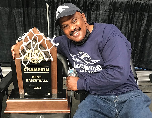 Randy Johnson, who played on the Longwood team in 1979-80 that went to the NCAA Division III Final Four, holds the Big South Tournament trophy won March 6 by Longwood, giving the team a berth in the NCAA Division I Tournament this week.